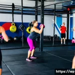 크로스핏 운동 원리 - A diverse group of adults training together in a bright, modern CrossFit gym ("box") with kettlebell...